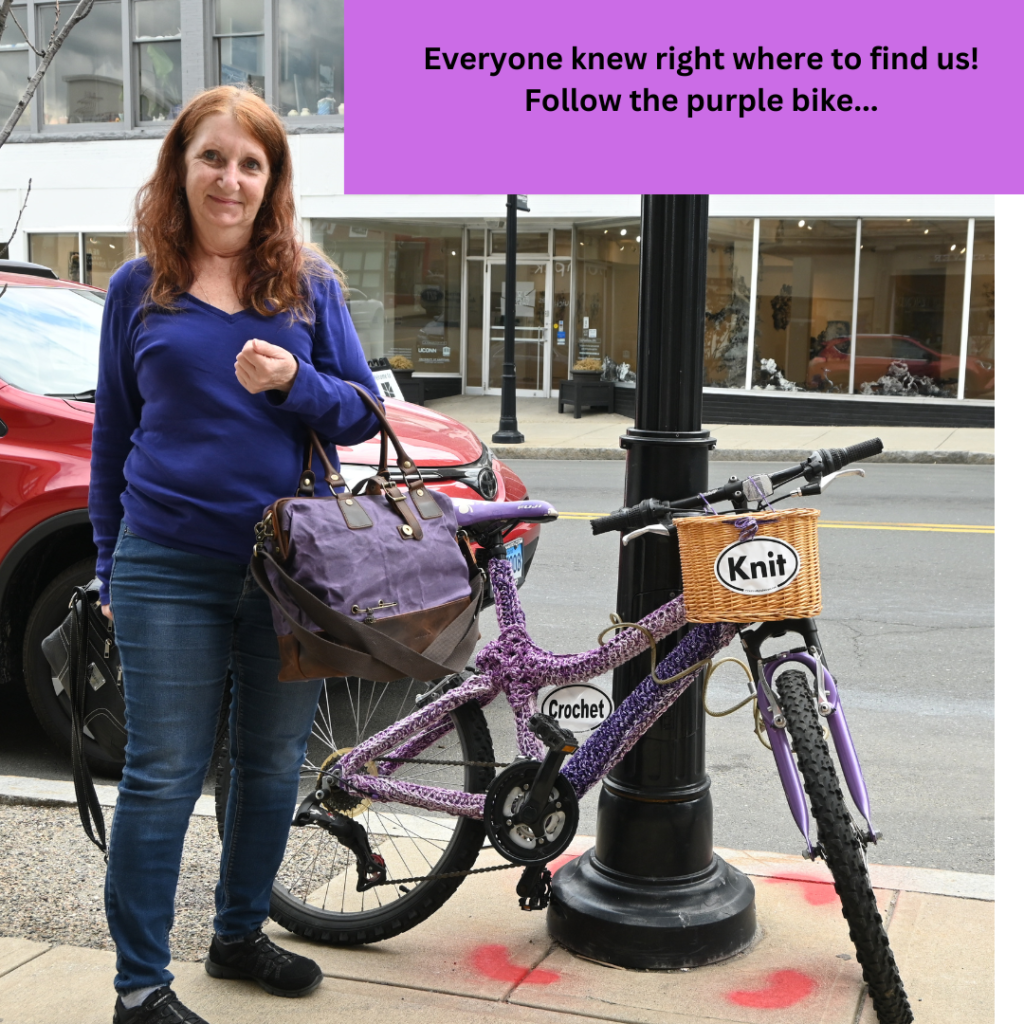 Crochet yarn bombed bike with visitor and Dellaq bag in hand
